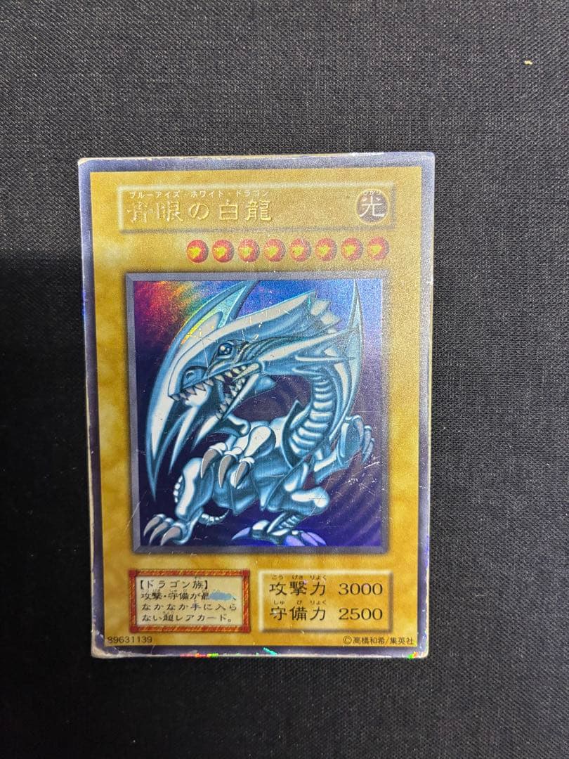 Blue-Eyes White Dragon Yu-Gi-Oh! trading card in early condition with visible signs of use