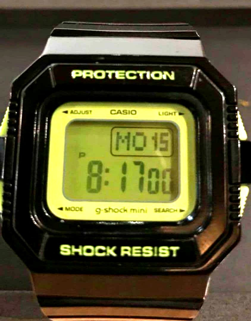 Casio G-Shock Mini digital watch with black and green body, digital display, and lime green backlight