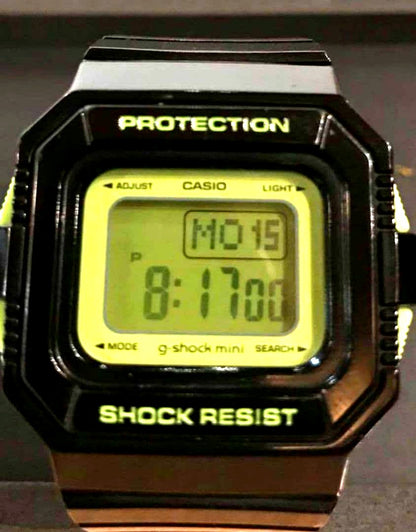 Casio G-Shock Mini digital watch with black and green body, digital display, and lime green backlight