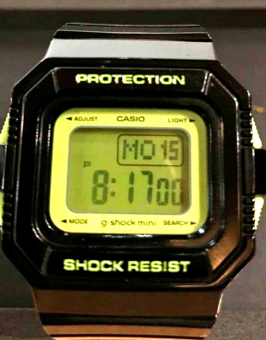 Casio G-Shock Mini digital watch with black and green body, digital display, and lime green backlight