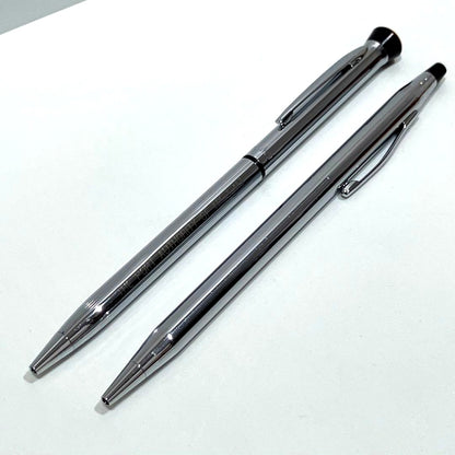 Two silver-colored ballpoint pens from Garland and Cross in a branded box, side by side