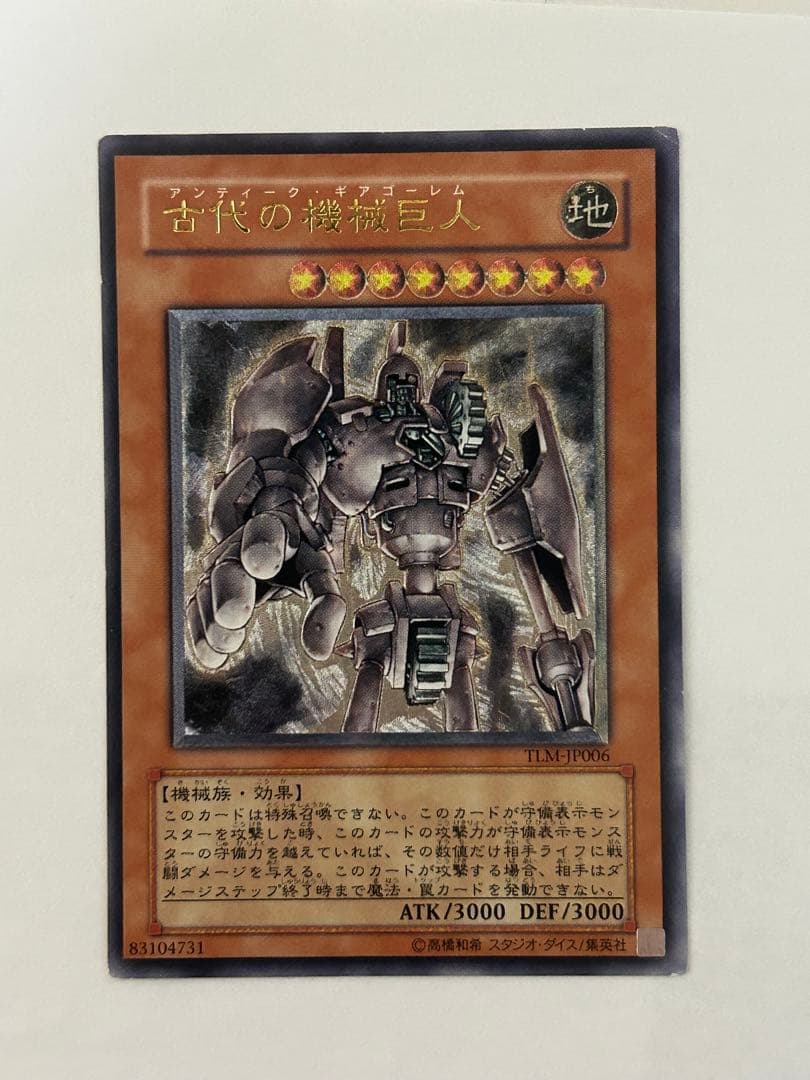 Antique Gear Golem Ultimate Rare Yu-Gi-Oh! card with worn edges and visible horizontal line on back