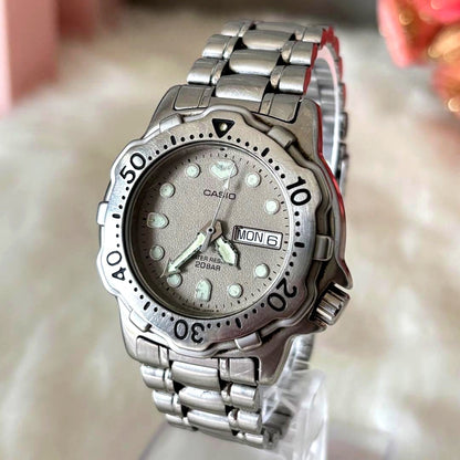 Casio Diver's 20BAR men's quartz watch with gray dial, day and date display, and stainless steel bracelet