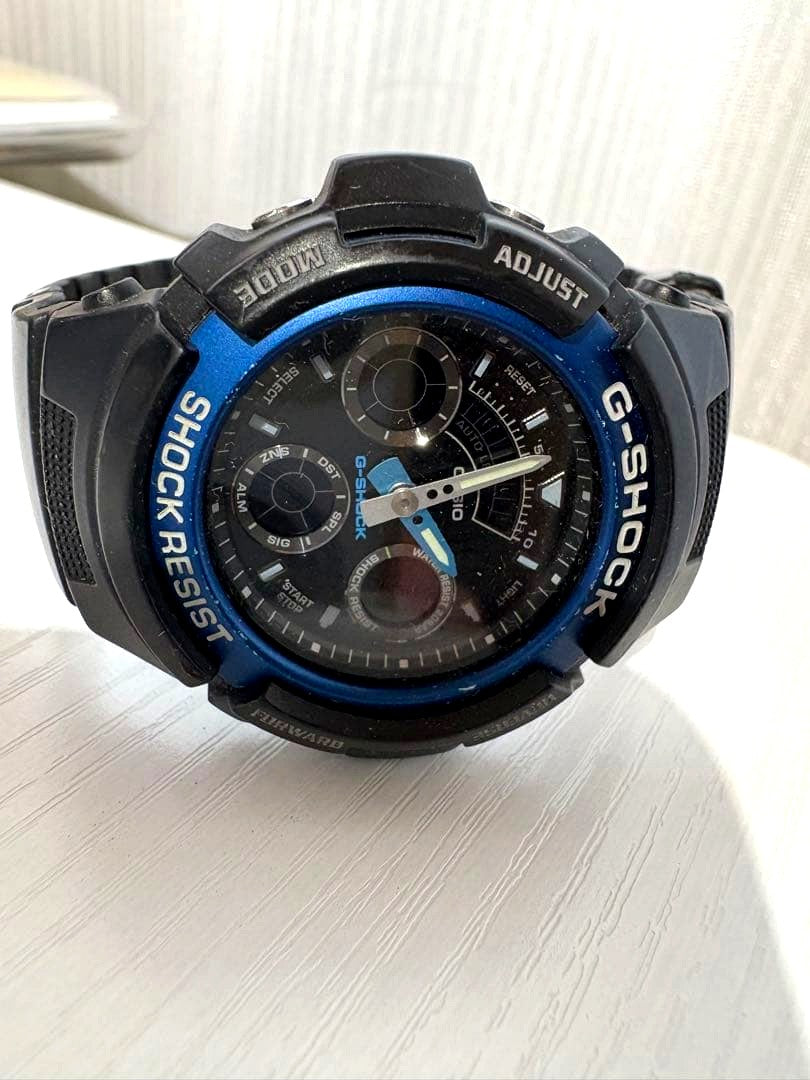 Casio G-Shock AW-591 digital analog watch with black body and blue ring, showing time on analog and digital display