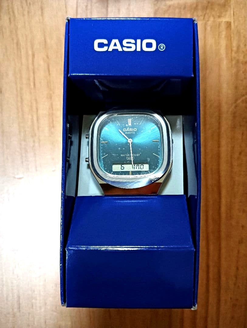 Casio AQ-240E-3A watch with blue-green dial showing analog and digital displays