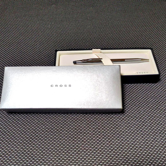 Silver Cross ballpoint pen with twist mechanism alongside its gift box and instruction manual
