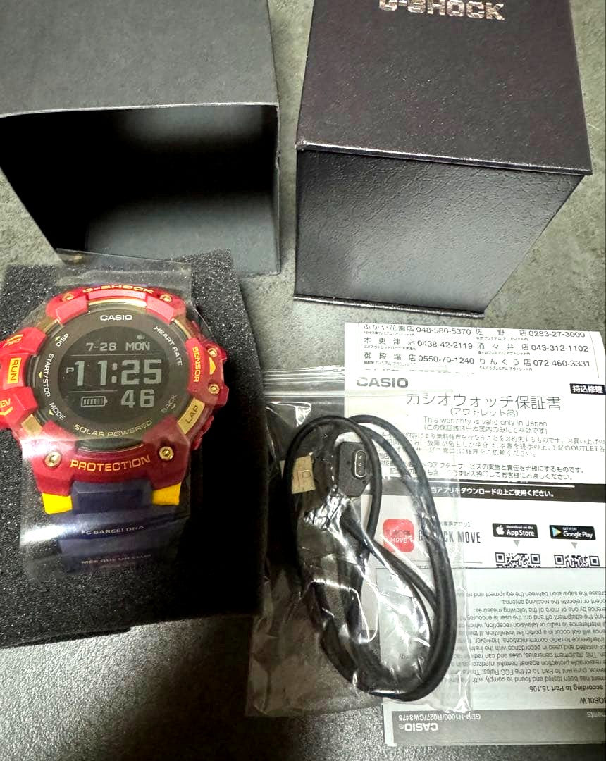 Casio G-Shock GBD 1000 digital watch with red resin band and charger cable