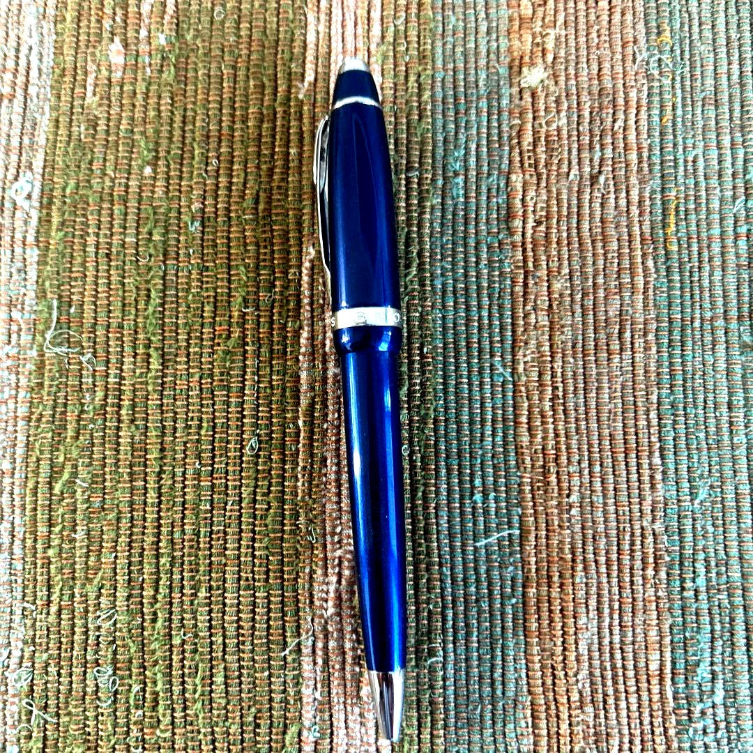 Cross blue metal ballpoint pen body with silver accents shown without cap or refills