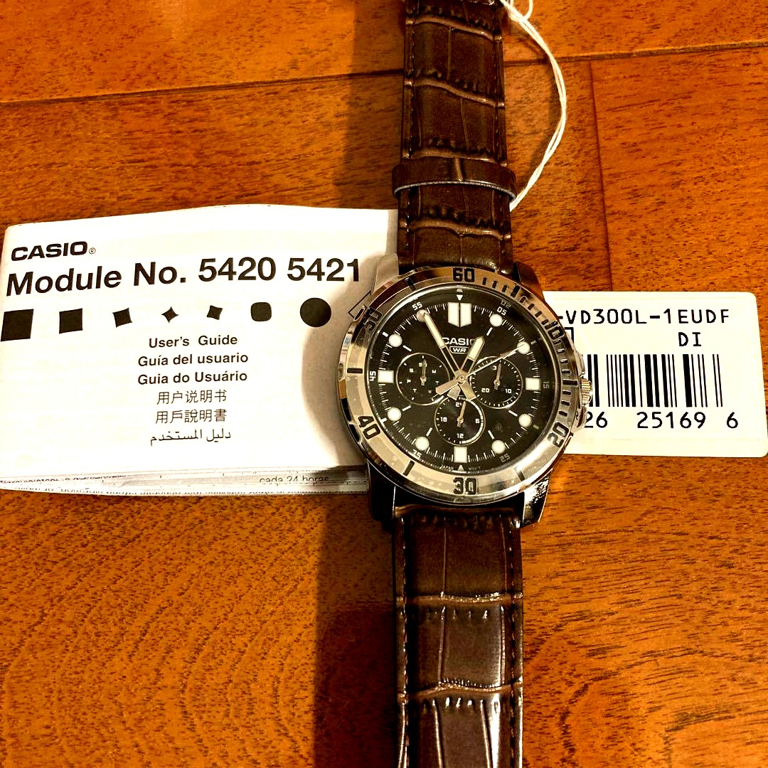 Casio International Model wristwatch with black dial, stainless steel band, day and date display