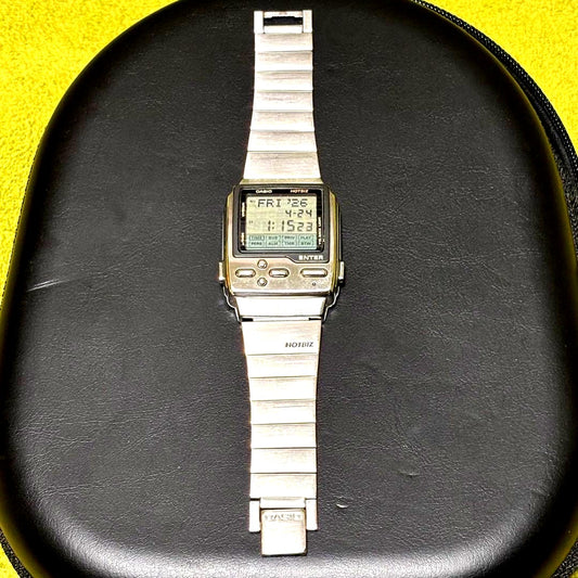 Casio DB-2000 digital wristwatch with cross directional keypad and retro 1990s design showing slight wear
