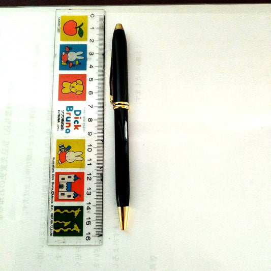 Mitsubishi black ballpoint pen with gold hardware and black ink on a white background