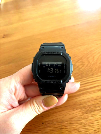 Casio G-Shock black digital watch with rubber band showing the digital display