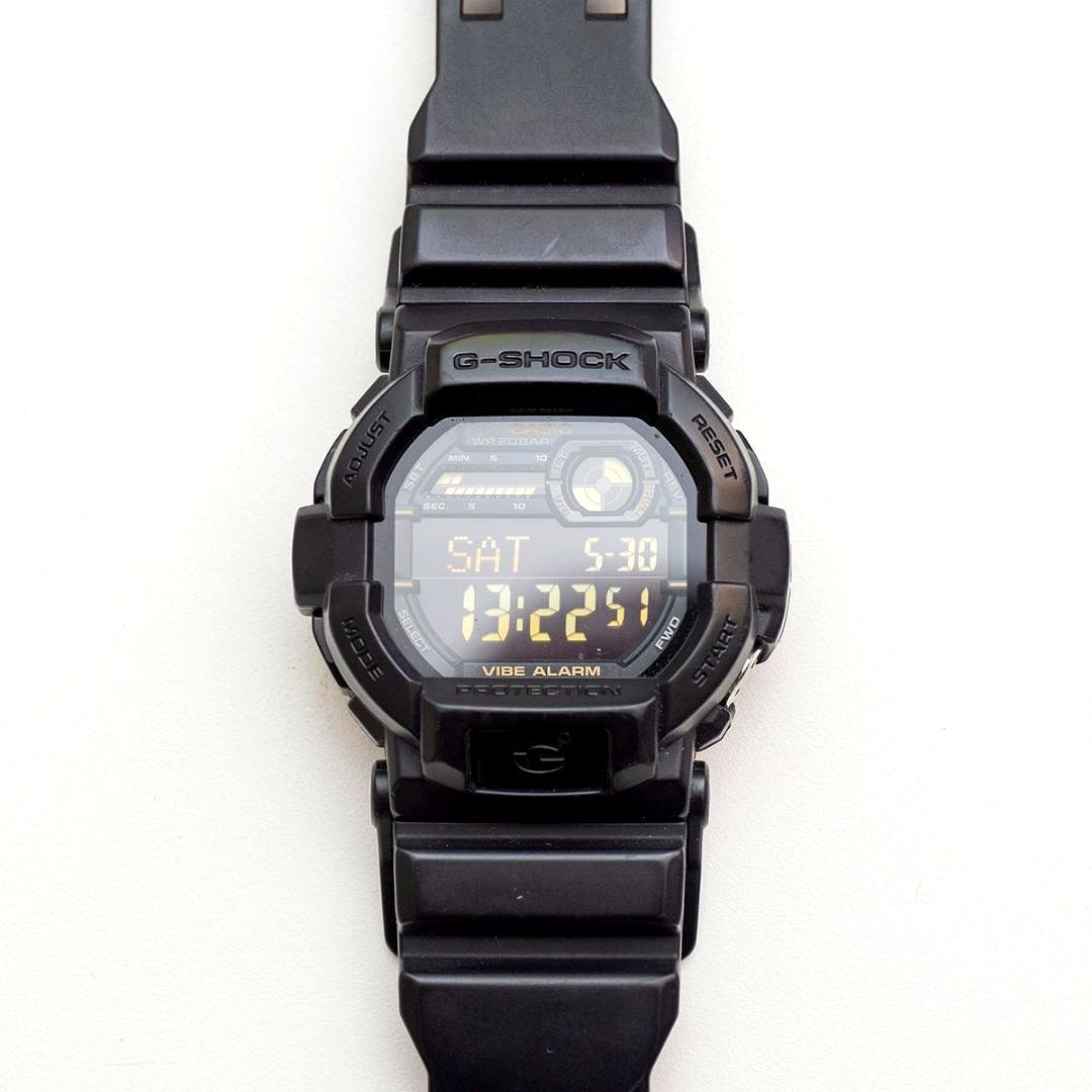 Casio G-Shock GD-350 wristwatch with black case and band, showing LCD screen and minor wear