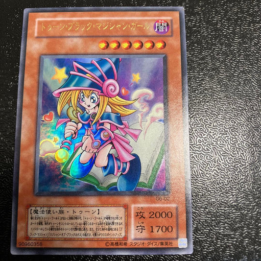 Bandai Toon Black Magician Girl Ultra Rare trading card showing visible wear, dents, creases, and chips