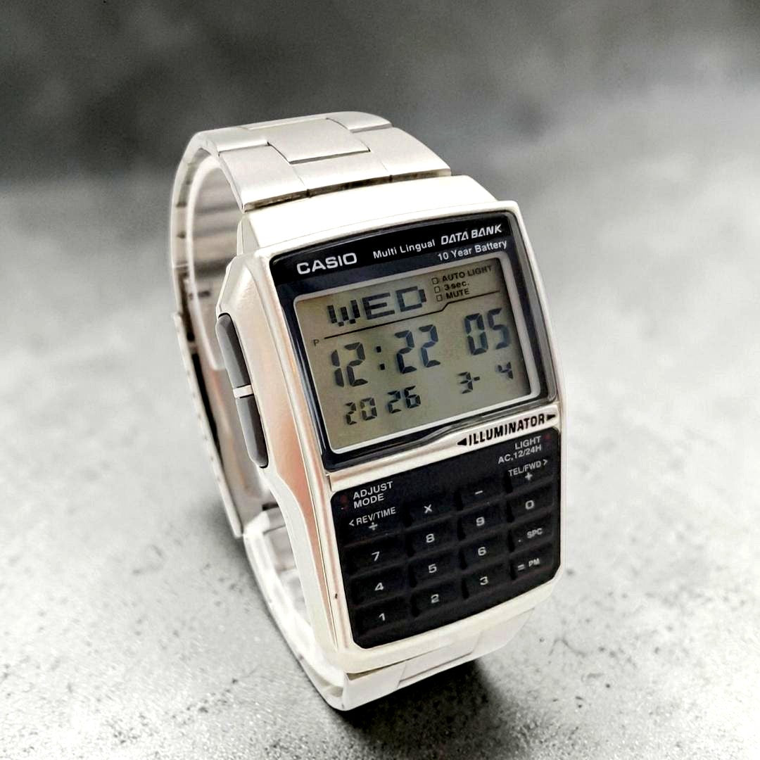 Casio Data Bank DBC-32 digital watch with silver and black retro face, calculator, and world time features