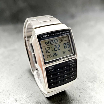 Casio Data Bank DBC-32 digital watch with silver and black retro face, calculator, and world time features