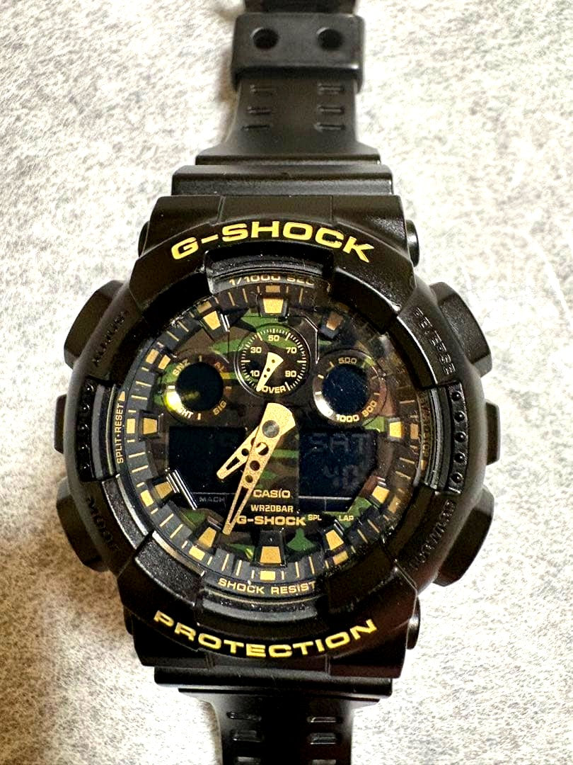 Casio G-Shock GA-100CF men's watch with camouflage dial, resin band, and digital analog display