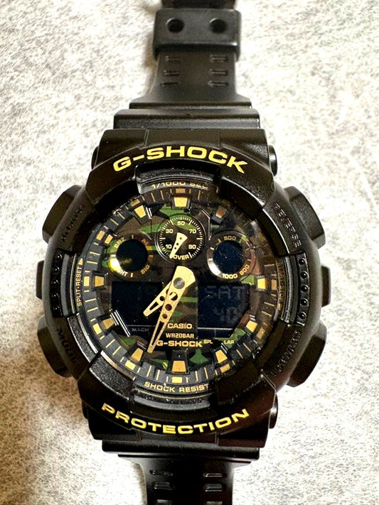 Casio G-Shock GA-100CF men's watch with camouflage dial, resin band, and digital analog display
