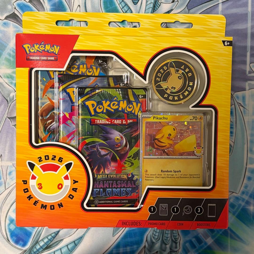 Pokemon Day 2026 Collection English version box with Pikachu promo card, coin, and three booster packs