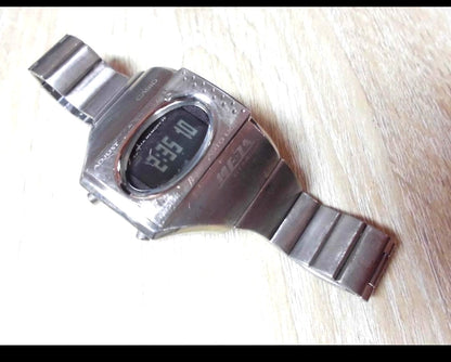 Casio ME-100T digital watch with silver stainless steel band and titanium back case