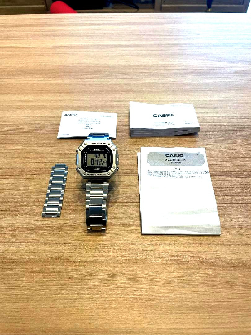 Casio W-218HD-1AV silver wristwatch with manual, guarantee card, and extra bracelet included