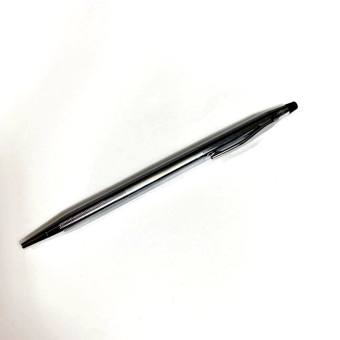 Used Cross brand silver ballpoint pen with blue ink shown on a white background