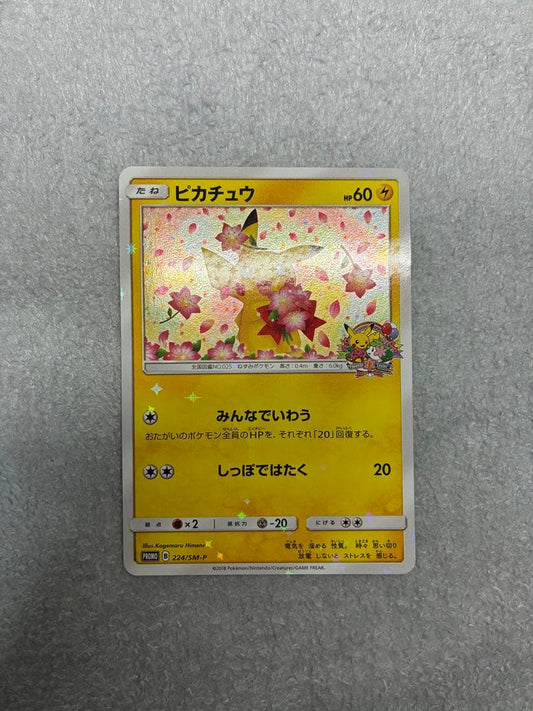 Pokemon Center 20th Anniversary Pikachu promotional card 224/SM-P in protective sleeve with loader and cardboard support