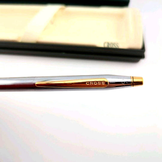 CROSS silver ballpoint pen with gold accents shown alongside its dedicated case