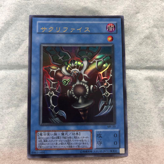 Yu-Gi-Oh Ultra Rare Sacrifice trading card with character shift error in protective sleeve and packaging