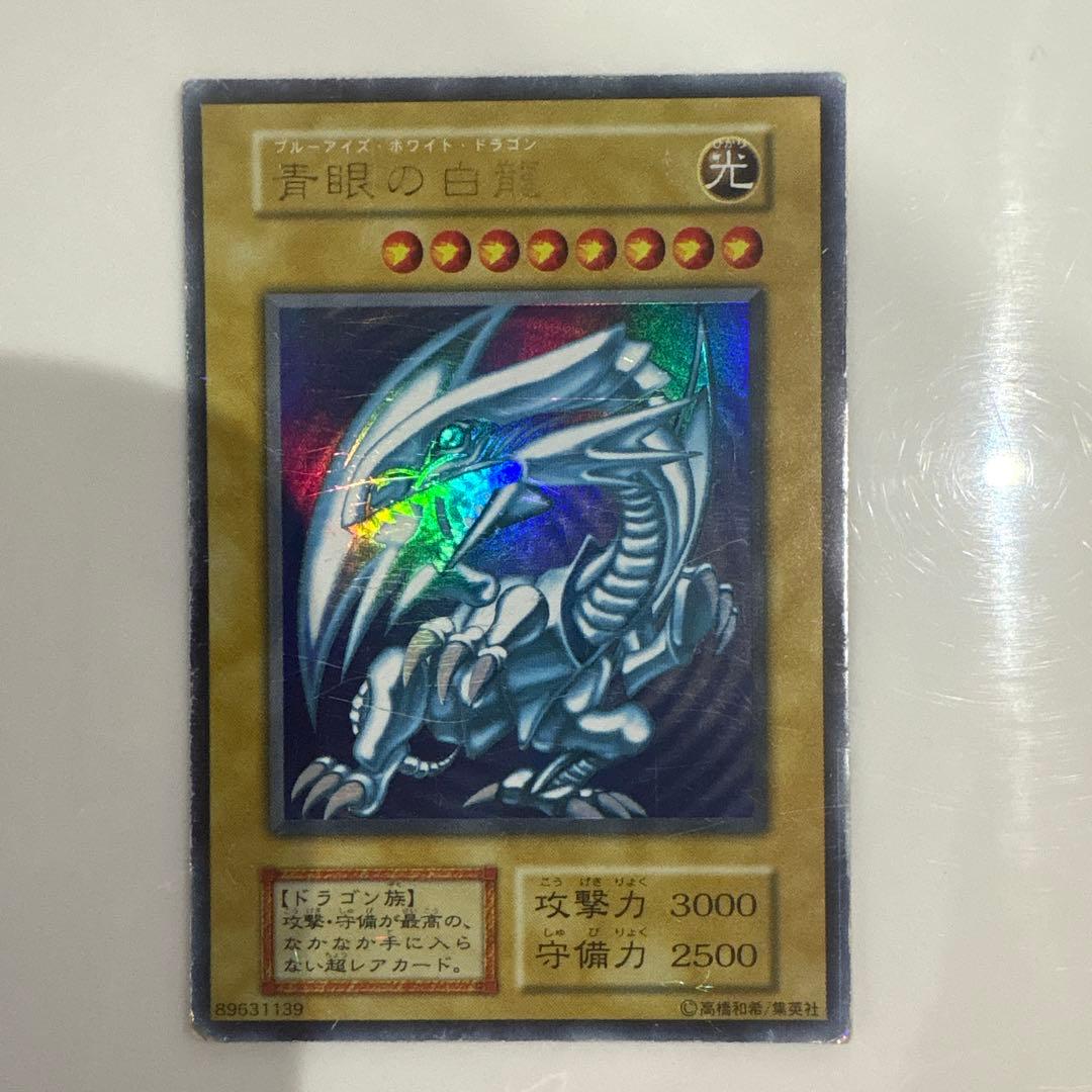 Yugioh Blue-Eyes White Dragon Ultra Rare Early Edition trading card showing signs of use and corner creases