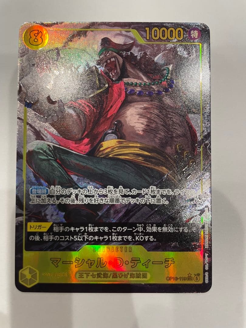 One Piece Marshall D. Teach collectible card in protective sleeve and case showing minor wear