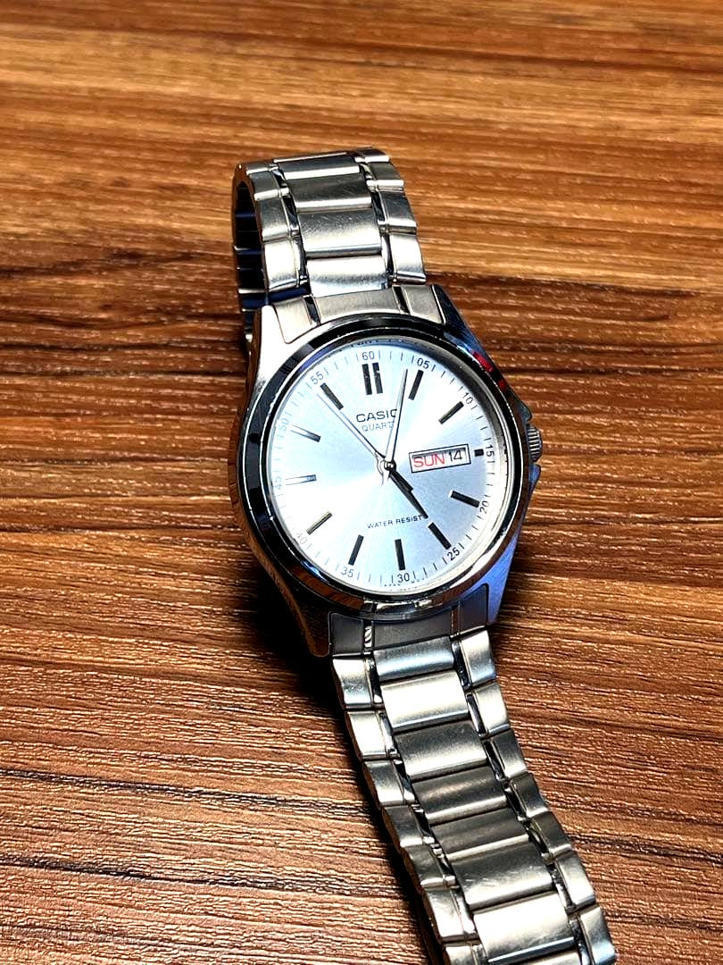 Casio MTP-1239DJ quartz watch with silver sunray dial, day and date display, and stainless steel case