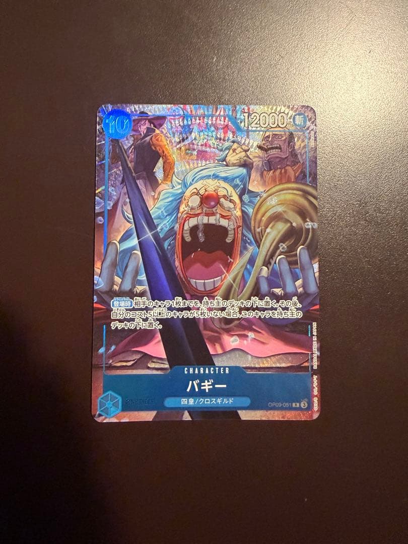 One Piece Buggy Character Card OP09-051 in protective sleeve with no visible scratches or stains
