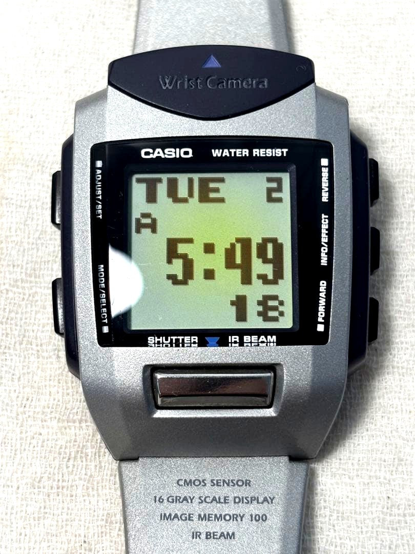 Casio Wrist Camera WQV-1 showing front view with functional buttons and visible scratches and marks