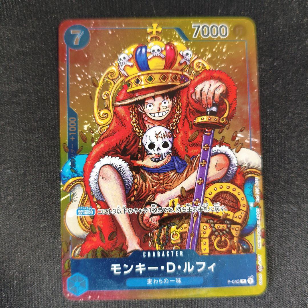 One Piece Monkey D. Luffy P-043 collectible card showing front with minor scratches and paint peeling on back