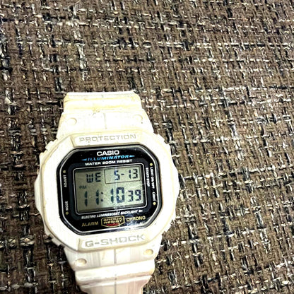Casio G-Shock DW-5600E white digital watch showing square face and white strap