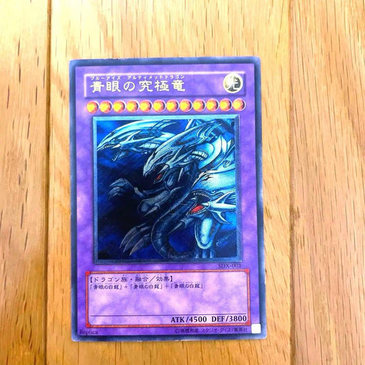 Yu-Gi-Oh Blue-Eyes Ultimate Dragon Ultra Rare SDX-001 card with visible scratches and chipping