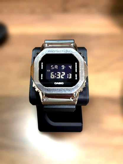 Casio G-Shock GM-5600-1JF square face watch with metal bezel in silver and black