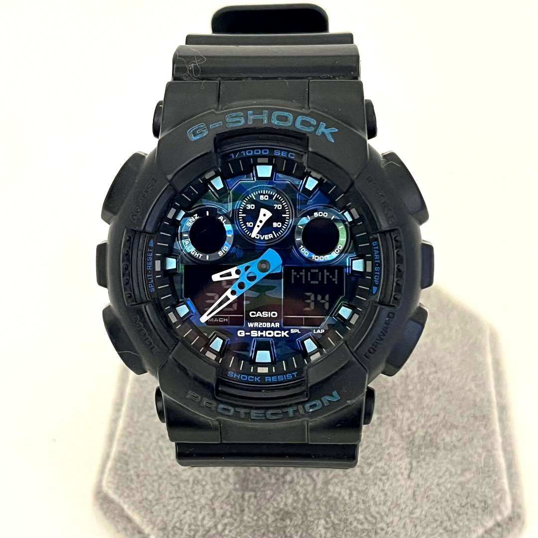 Used Casio G-Shock GA-100CB watch with camouflage pattern showing scratches on glass and band