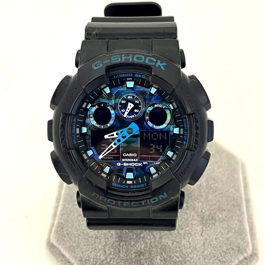 Used Casio G-Shock GA-100CB watch with camouflage pattern showing scratches on glass and band