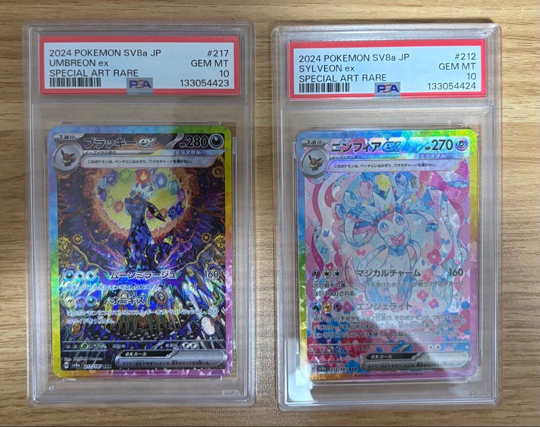 PSA10 graded Pokémon cards featuring Ninfiaex and Boulaxex with serial numbers in a collector set