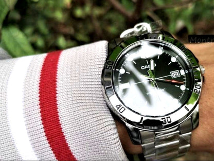 Casio analog wristwatch with large black dial, silver stainless steel band, and mineral glass face