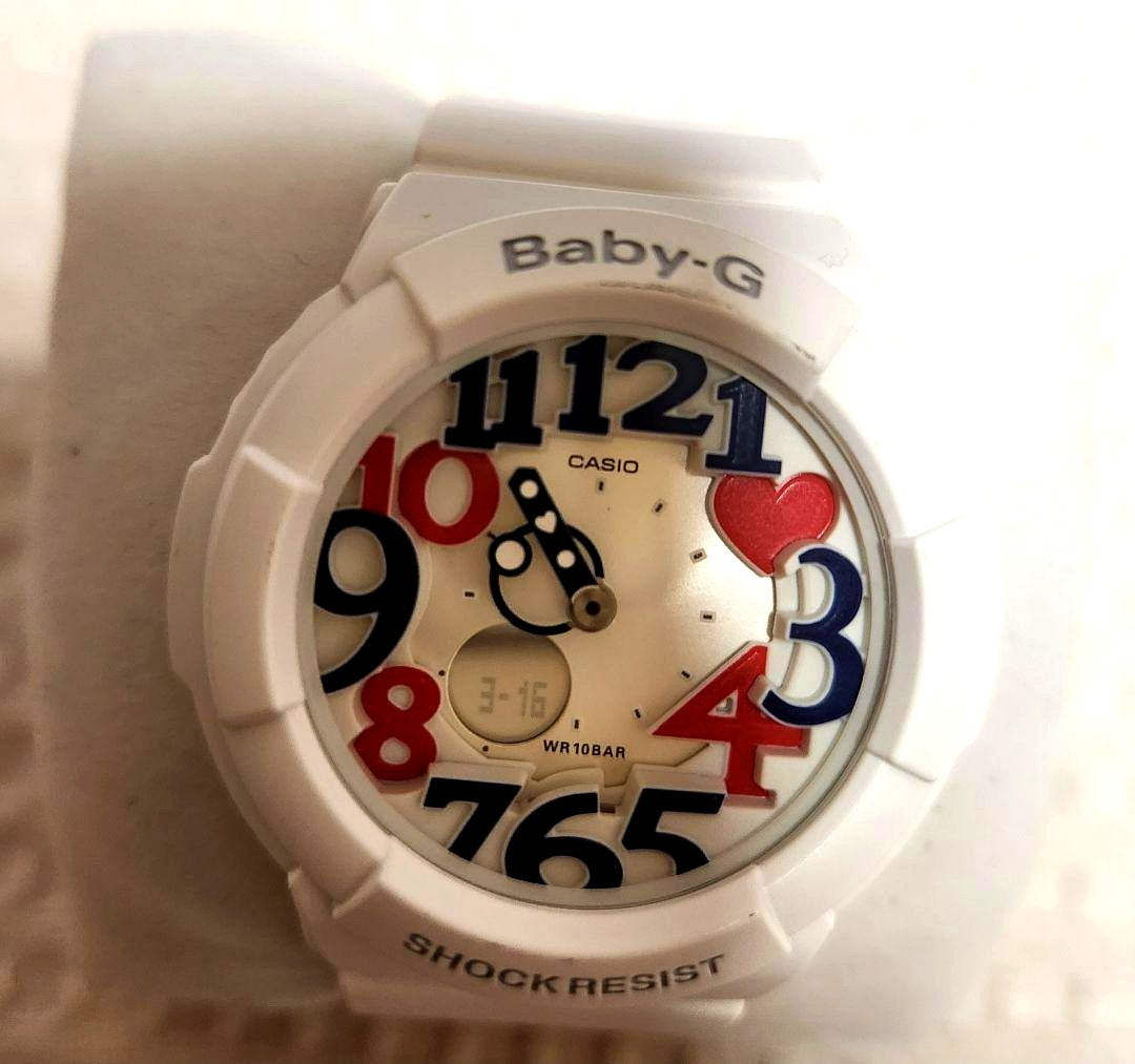 Casio Baby-G white women's watch with colorful numbers and heart designs, displayed with its box