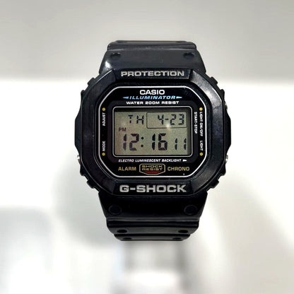 Casio G-Shock DW5600E Speed Series black digital watch with square face and greenish-blue EL backlight