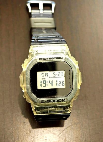 Casio G-Shock DW-5600SK-1 digital watch with clear bezel and black band showing square face