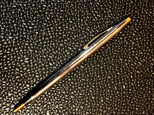 Cross ballpoint pen with silver and gold body, dark blue ink, made in USA, showing signs of use