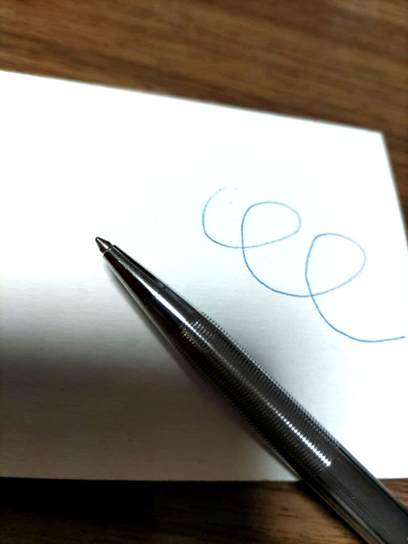 Cross ballpoint pen with silver body and detailed knurled grip, featuring blue ink