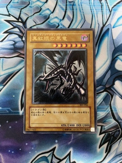 Yugioh Red-Eyes Black Dragon Relief vintage trading card with minor wear, shown in protective sleeve