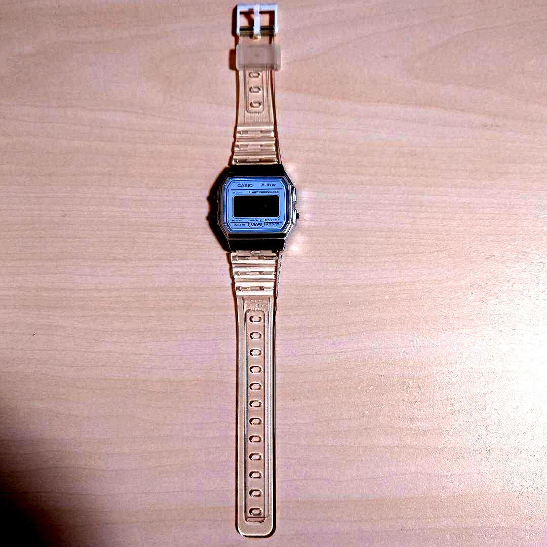 Casio F-91W clear silver digital watch showing the front display and strap