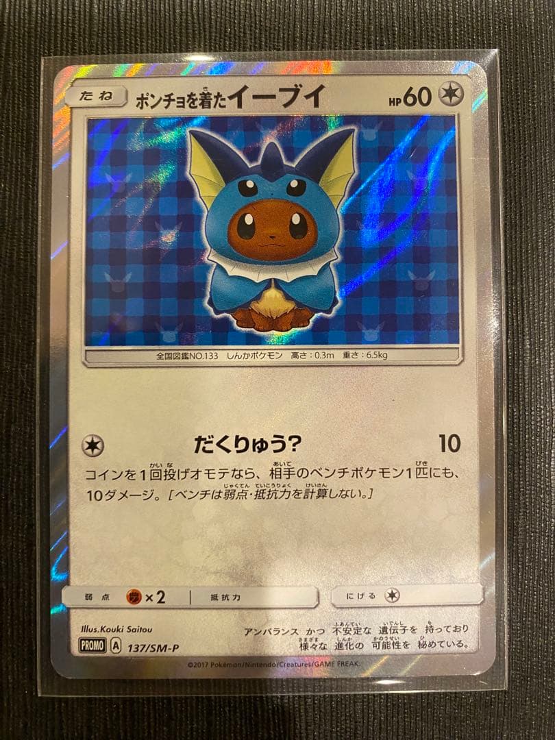 Pokemon promotional card featuring Eevee wearing a poncho with slight crease and small chip